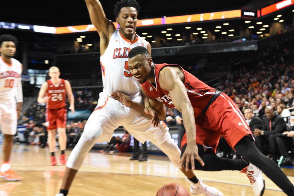 Redshirt sophomore guard Torin Dorn charged a Clemson player on his way to the basket on March 7 during the first round of the ACC Tournament. Dorn scored 7 points, but the Pack was defeated, 75-61.