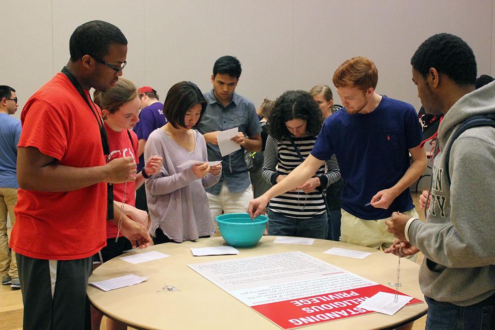 A group of students participate in activities during the Tunnel of Oppression Tuesday. Participants were asked to rotate around tables that analyzed different forms of privilege. The group was asked to make paperclip chains to show its own privilege, or lack thereof.
