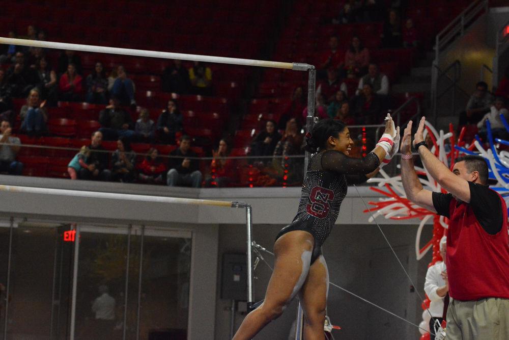 Junior gymnast Chelsea Knight high fives the NC State Assistant Coach Bob Starkell after her successful performance in the uneven bars event at the Reynolds Coliseum on March 18, 2017. The Wolfpack won 3rd place with the score of 194.875 in the meet with George Washington University, University of New Hampshire,&#160;UNC Chapel Hill, University of Pittsburgh, and Towson University.
