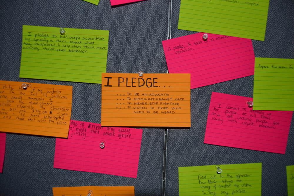 Students pin notecards to the pledge board in the Empowerment Room at the end of Tunnel of Oppression on Wednesday. Each notecard represented what a student pledges to do for oppressed populations after completing the tour.