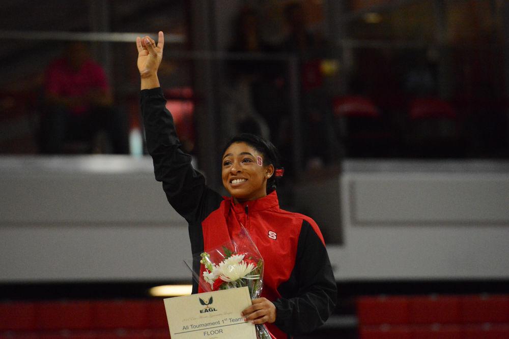 Junior gymnast Chelsea Knight poses celebrates with a Wolfpack symbol as she won second place on the Floor Exorcise event at Reynolds Coliseum on March 18, 2017. Knight receives 9.775 in the vault event, 9.750 in the bars event, 9.775 in the beam event, and 9.875 in the floor event which she won 2nd place in. She also won 3rd place with her all around results of 39.175. The Wolfpack won 3rd place with the score of 194.875 in the meet with George Washington University, University of New Hampshire,&#160;UNC Chapel Hill, University of Pittsburgh, and Towson University.