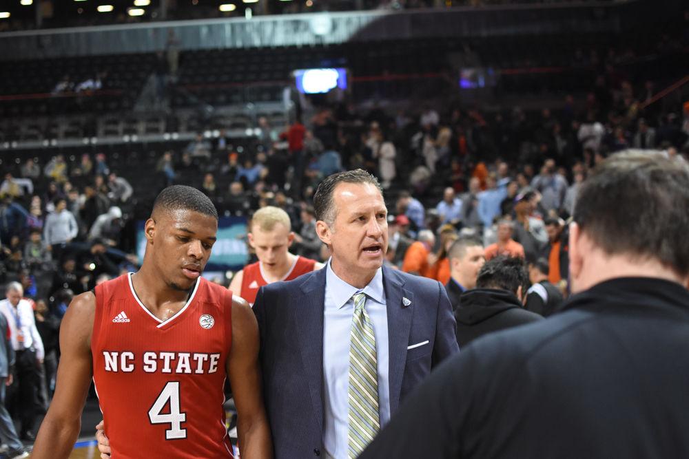 Coach Mark Gottfried walks back to the locker room with Freshman Dennis Smith Jr. after his last game as the coach of the Wolfpack. The Wolfpack was defeated by Clemson, 75-61 in Brooklyn, New York in Barclays Center during the first round of the ACC Tournament.