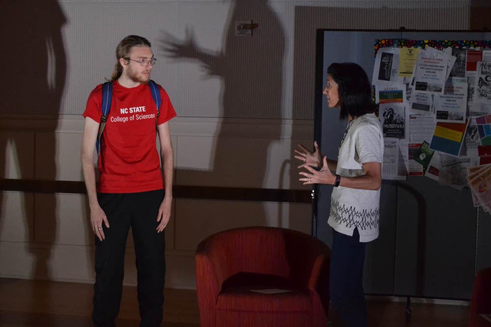 Carl Hintz, a junior studying mathematics, and Marcy Bullock, an NC State Career Counselor, act out a scene about the Dakota Access Pipeline during the Tunnel of Oppression in the State Ballroom on Wednesday. Hintz and Bullock volunteered their time to help out with the annual event.