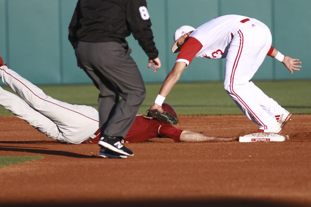 Junior short stop Joe Dunand tags out a Florida State runner at second base as he dives back to the bag in their game on April 8, 2017. The Wolfpack beat the Seminoles 4-3 in the game at Doak Field.&#160;