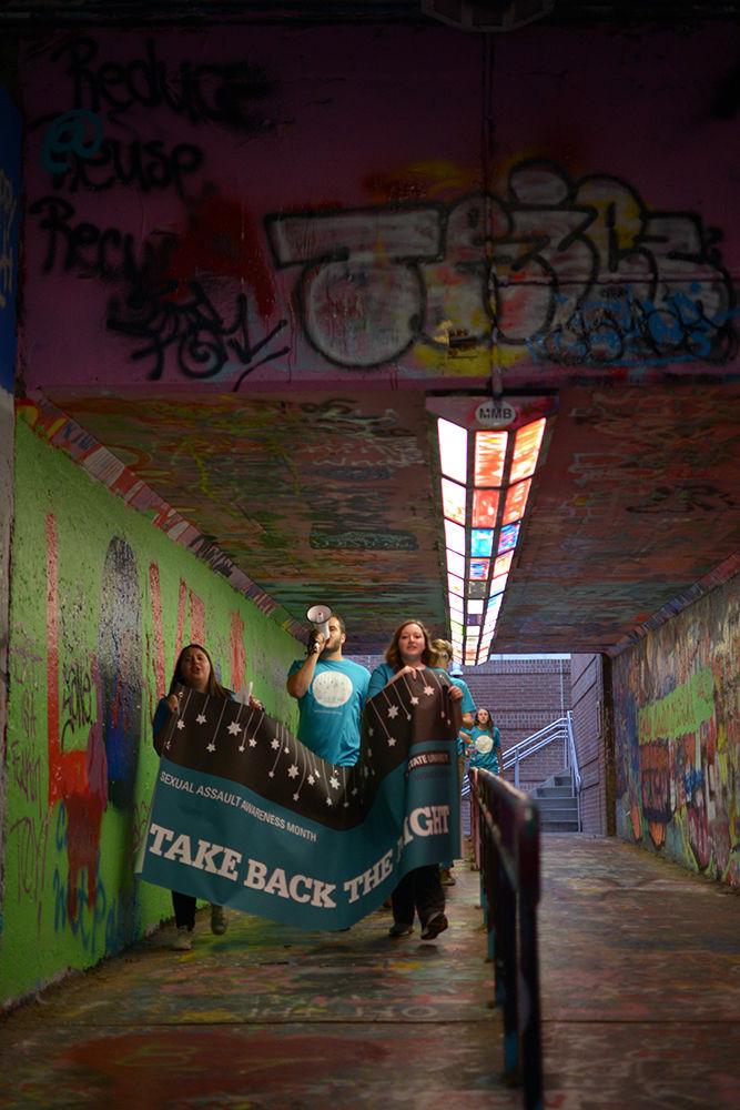 Marchers for Take Back the Night go through the Brickyard on Wednesday while chanting, "Wolfpack unite, take back the night!" The Women&#8217;s Center hosted the event as part of Sexual Assault Awareness Week.