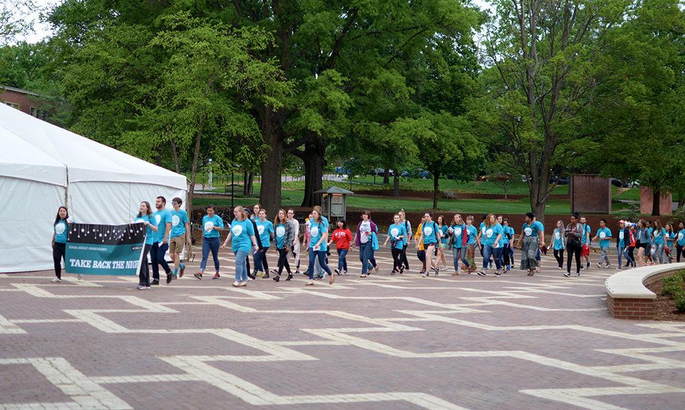 Marchers for Take Back the Night go through the Brickyard on Wednesday while chanting, "Wolfpack unite, take back the night!" The Women&#8217;s Center hosted the event as part of Sexual Assault Awareness Week.