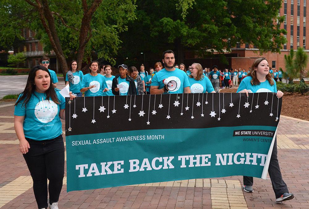 Students march through the Brickyard as a part of the Take Back the Night event on Wednesday. The event was started to help put a stop to rape culture and to address issues of sexual violence on campus.