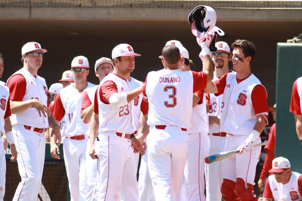 Junior short stop Joe Dunand gets high fives from his teammates as he crosses home plate after hitting a home run in the Wolfpack's 8-4 win over Florida State on April 9, 2017. Dunand had 2 hits, 2 runs, and 2 RBIs in the win at Doak Field.