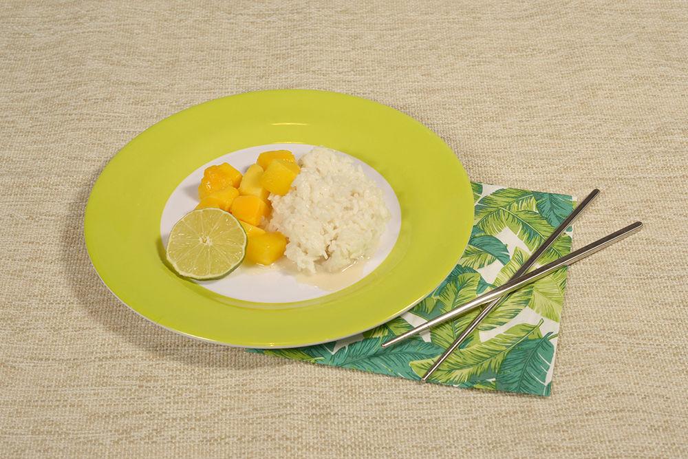 Mango and sticky rice is a classic Thai dish with simple ingredients. Garnish with a lime slice and enjoy.
