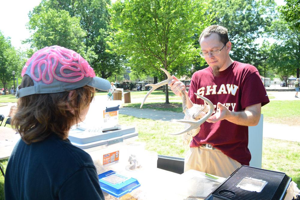Eric Butler, an NC State alumnus who studied zoology, teaches a young spectator about the deer skull Butler is holding. Butler now works with Shaw University, which was heavily involved in the Raleigh March of Science, and he voluteered to educate visitors to the community science fair held in Moore Square about a variety of animal life. The science fair was held in conjunction with the Raleigh March for Science on April 22, 2017.