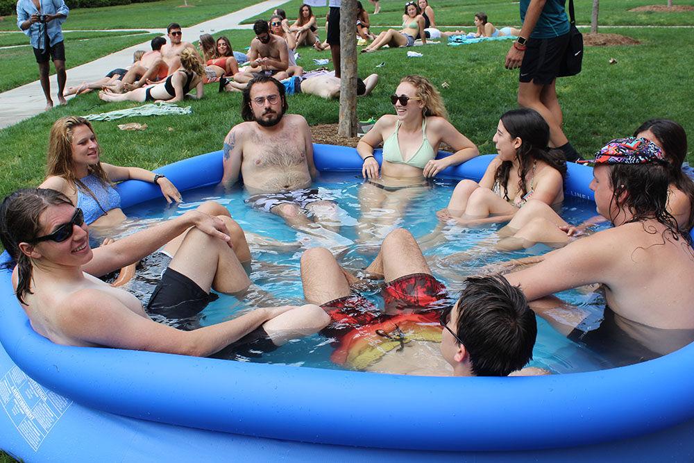 Students in the International Village relax in a blow-up pool outside of Alexander Residence Hall during the spring of 2017.&#160;