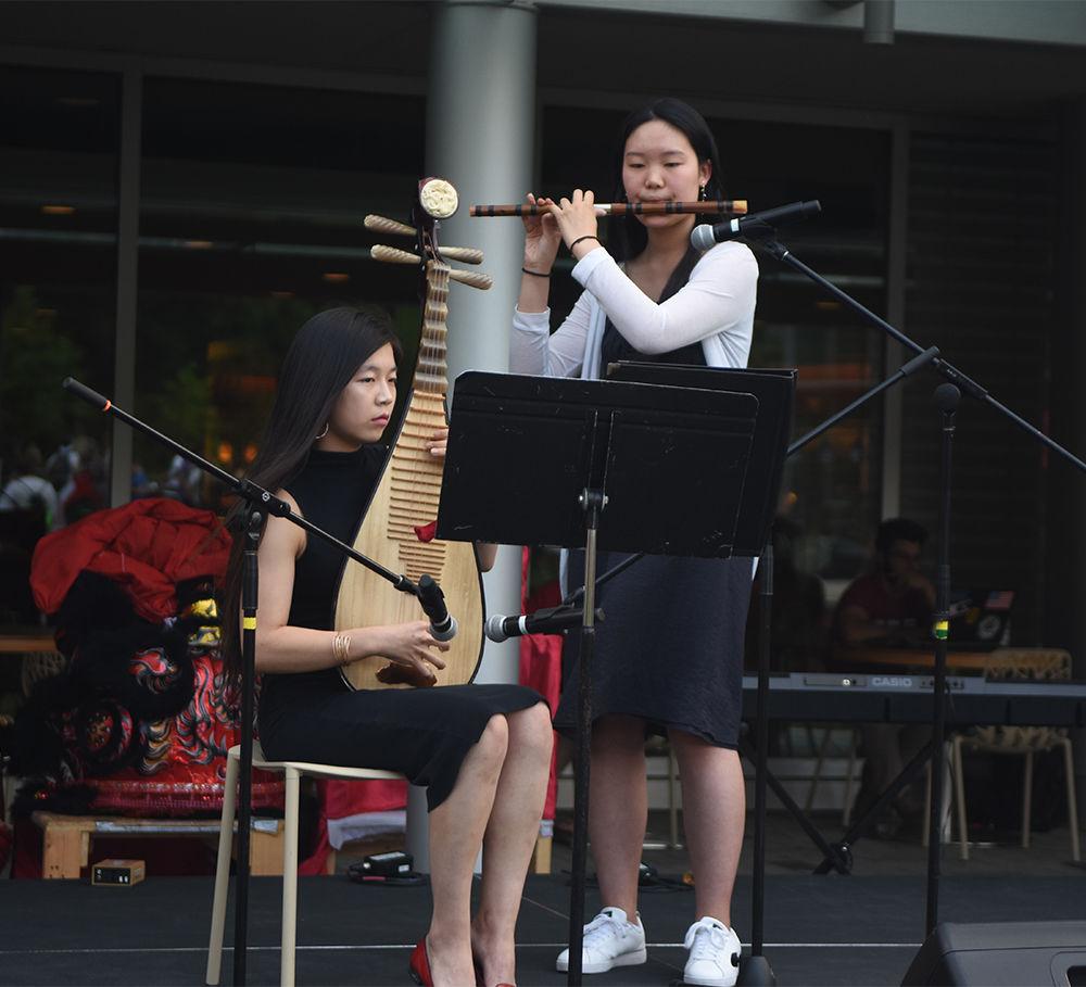 Jessica Qu, a sophomore studying nutrition science, plays a Chinese wooden instrument called a "pipa" and Naiomi Xu, an sophomore in the inter-college transfer program, plays a Chinese instrument called a "dizi" on stage during the International Festival on Stafford Commons Friday. The International Festival, sponsored by Student Involvement, Student Government, the Multicultural Student Affairs Office and the Office of International Services, gave students the opportunity to learn about different cultures around the world.