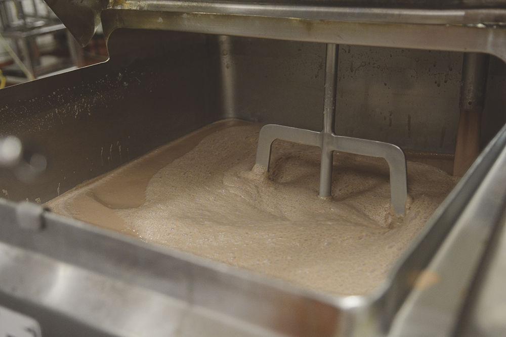 Chocolate ice cream is mixed in a large container early April 12 in the Robert H. Feldmeier Dairy Processing Lab. The lab pasteurized the ice cream mix on Tuesday and allowed the mix to sit for a cure period, a practice that improves the ice cream.&#160; The simple flavors, chocolate and vanilla, are filled first in a day's production, followed by more difficult flavors like mint chocolate chip, Wolftracks, etc.