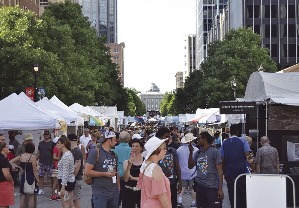 People and vendors crowd Fayetteville St. in downtown Raleigh during Artsplosure on Saturday, May 20, 2017. Although the event was free, food, artwork and crafts were sold to support local artists and businesses.