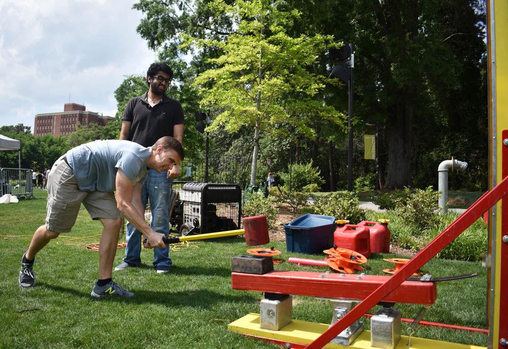 Alex Blaisdell, a junior studying aerospace engineering, slams down the hammer on the high striker challenge at Stafford Commons on Friday, April 28. Due to the physical aspect of the challenge, Blaisdell was one of the few students to hit the bell at the top.
