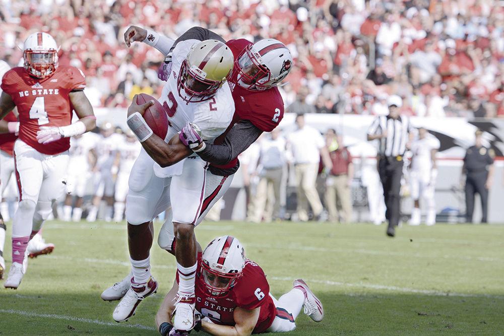 Redshirt freshman safety Josh Jones and redshirt junior safety Tim Buckley take down Boston College quarterback Tyler Murphy Saturday, Oct. 11, 2014, at Carter-Finley Stadium. Jones led the Pack defensively with nine solo tackles and four assists. The Wolfpack tacked on another loss to the season on a score of 14-30, and it went on to finish the 2014 season with an 8-5 record.