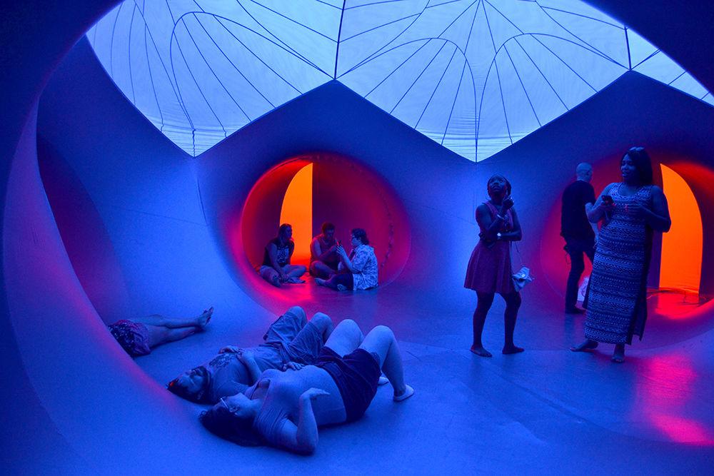 People hang out inside of the Katena Luminarium at Artsplosure on Fayeteville St. in downtown Raleigh on Saturday, May 20, 2017. They sat in pockets that were air conditioned to escape the summer heat. The Katena Luminarium was made by Architechts of Air and all of the light inside was produced by the sun.