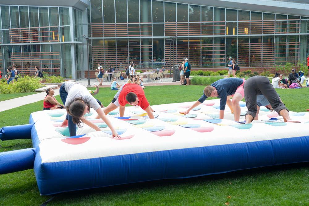 Students play giant inflatable twister, one of many activities set up on Stafford Commons on April 28. LDOC, which stands for last day of classes, was celebrated with free food from local food trucks and games of life-size hungry hippos, high striker, sumo wrestling, balloon darts and ring toss.