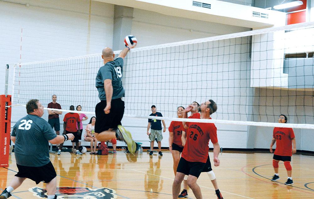 Tommy Kraus, Captain in the U.S. Army from Fayetteville, hits the ball over the net while fellow teammate Steve Ridgeway and opposing team member Tiger Posey from Wilkes County look on during a volleyball match at Carmichael Gymnasium as part of the Special Olympics Saturday, Jun 3 2017. Kraus' team, the Cumberland County Troublemakers won the match. Volleyball was among several events taking place on campus during the Special Olympics Summer Games. The Olympics allow those with disabilities across North Carolina the chance to compete in various sporting events.