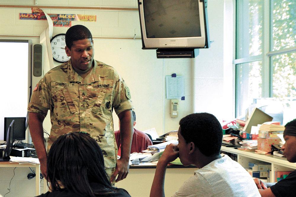A military recruiter discusses careers in the military to high school students at Longview High School during a career fair organized by American Justice Corps members.