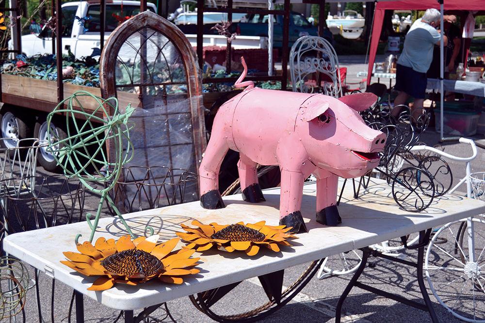 Metal lawn sculptures like sunflowers and pigs are sold at the Flea Market on the NC State Fairgrounds Saturday, May 20. Vendors were outside from 9 a.m.-6 p.m. selling their crafts.