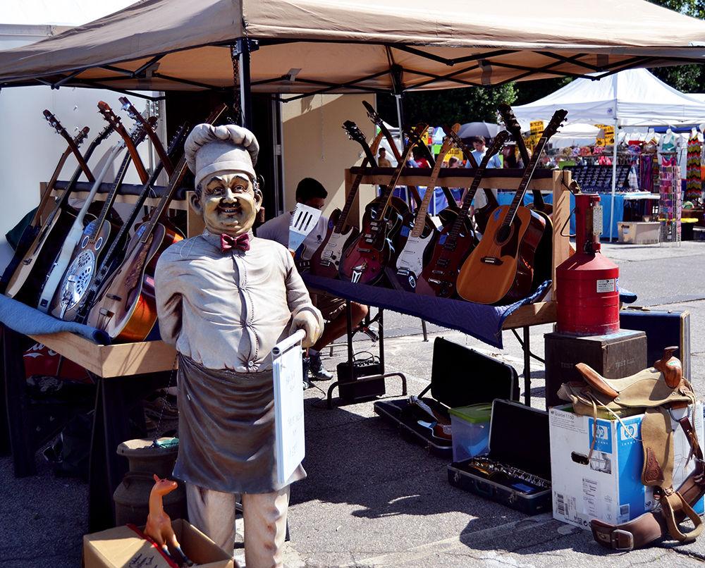 An outdoor vendor at the Flea Market sells guitars and lets people play them at the NC State Fairgrounds on Saturday, May 20. The vendor had both electric and acoustic guitars for sale.