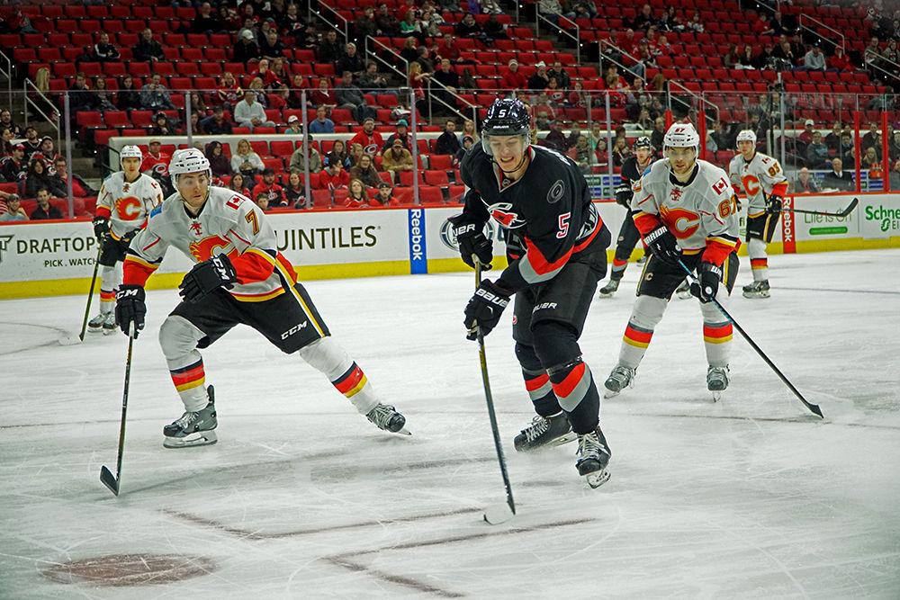 Carolina Hurricanes defender Noah Hanifin clears the puck past Calgary defender T.J. Brodie. The Hurricanes defeated the Calgary Flames 5-2 at the PNC Arena on Jan. 24, 2016.