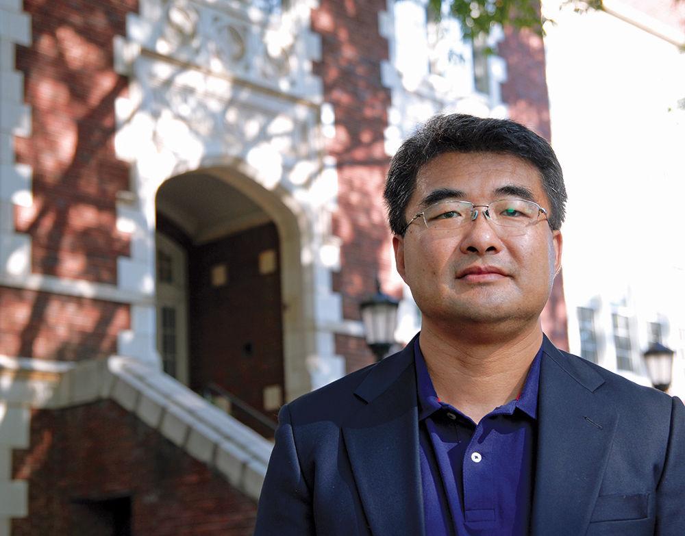 Professor Jianxin Hu stands in front of Wiley Elementary School where the next of his class's projects for the Wake County Public School System will take place on Wednesday, July 19. Hu teaches architecture at NC State and challenges his students with real world assignments building different projects for the Wake County Public School System. The project at Wiley Elementary will consist of the complete destruction and re-building of the school&#8217;s cafeteria and will provide new offices and classrooms.
