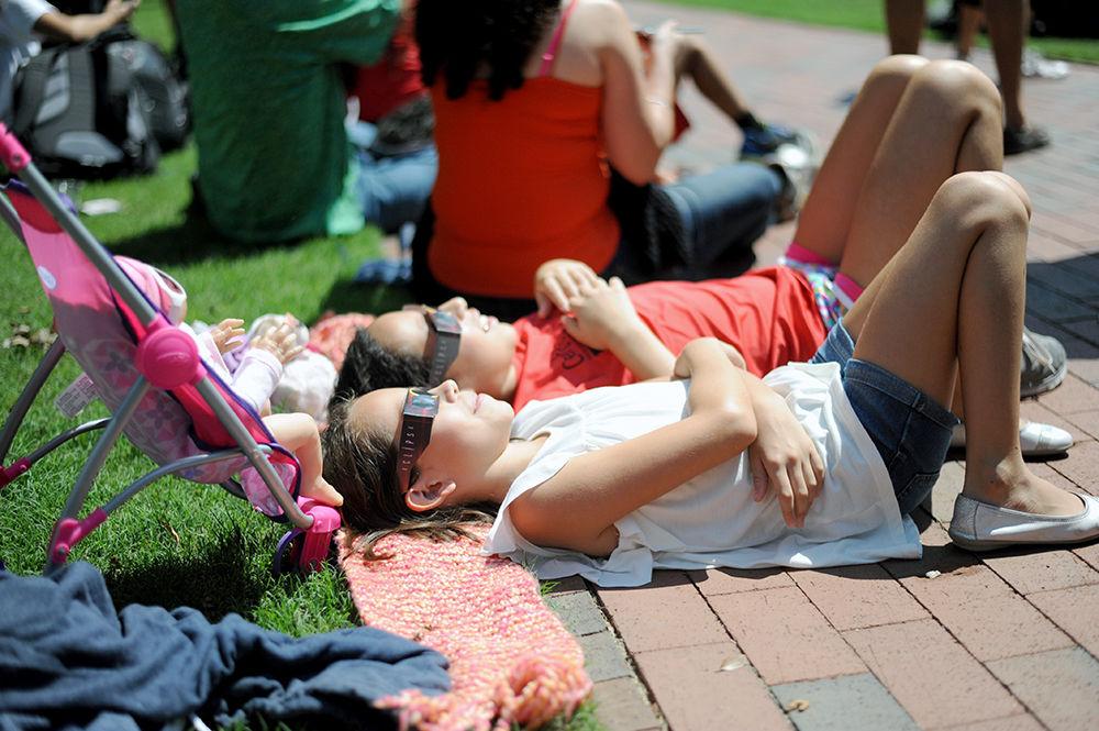 Two eclipse watchers view the eclipse on the wolf ear lawn on Monday, Aug. 21. Many individuals gathered around with their friends and got comfy on the grass to watch the eclipse. Glasses were handed out to many people so they wouldn't hurt their eyes.