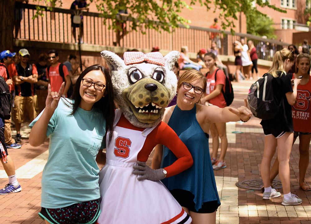 Jennifer Nguyen a third-year student studying chemistry and biology poses with Kyrsten Rudock a third-year student studying textile engineering pose with Ms.Wuf during the solar eclipse on Monday, Aug. 21. Ms. Wuf posed with students in the Brickyard waiting to see the eclipse.