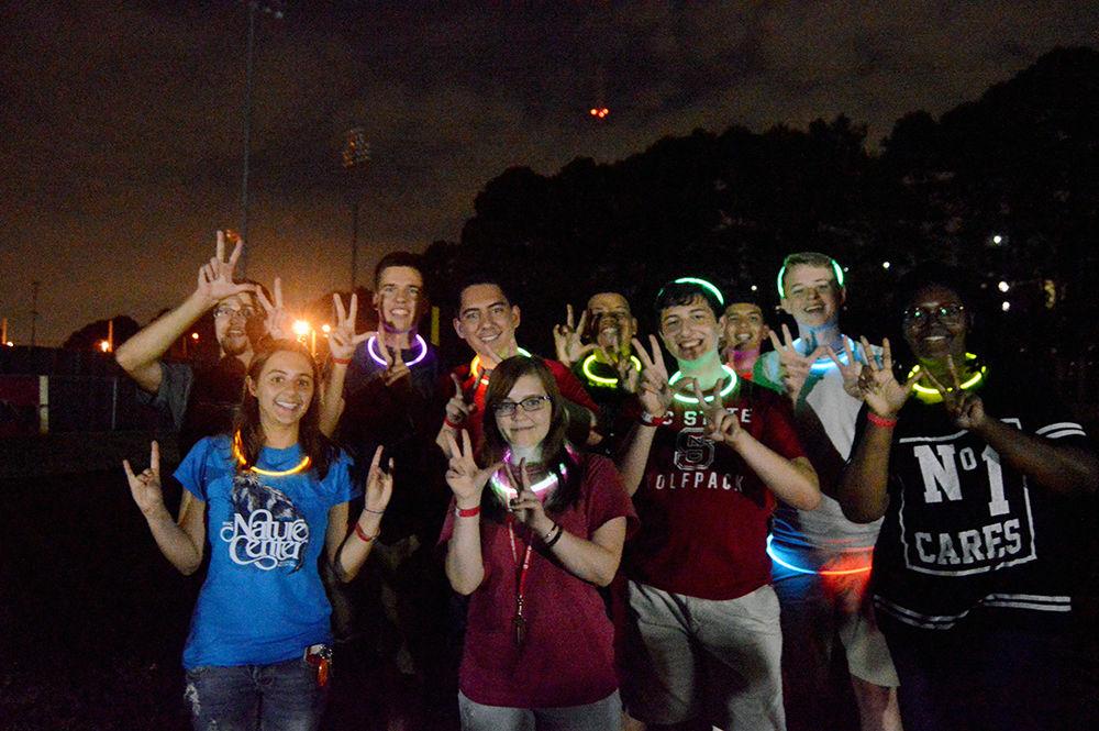 A group of friends wear neon lights waiting in line for the inflatables during Wolfpack After Dark on Lee Field Friday Aug. 25. Neon lights were passed out by the sponsor of Wolfpack After Dark, the Union Activities Board, to participating students.