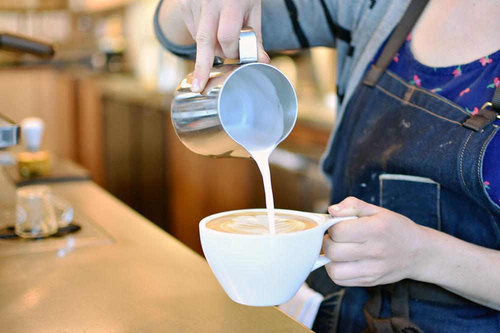 Julianne Gonski, a barista for Jubala Coffee on Hillsborough Street, mixes a latte with a design made from steamed whole milk. Gonski studied Art and Design and graduated from NC State in 2009.