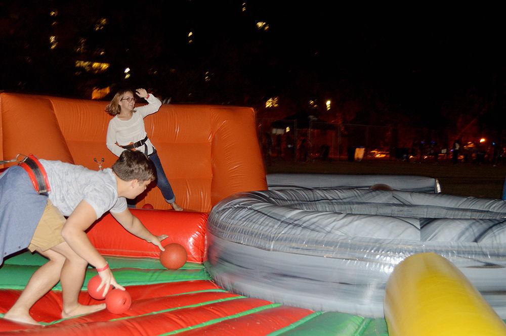Cecil Isaac Brown a first-year student in exploratory studies and Sophie Holmes a first-year student studying civil engineering play on a Hungry Hungry Hippo themed inflatable during Wolfpack After Dark on Lee Field Friday, Aug. 25. The inflatables provided were obstacle courses where friends go head-to-head in various challenges.