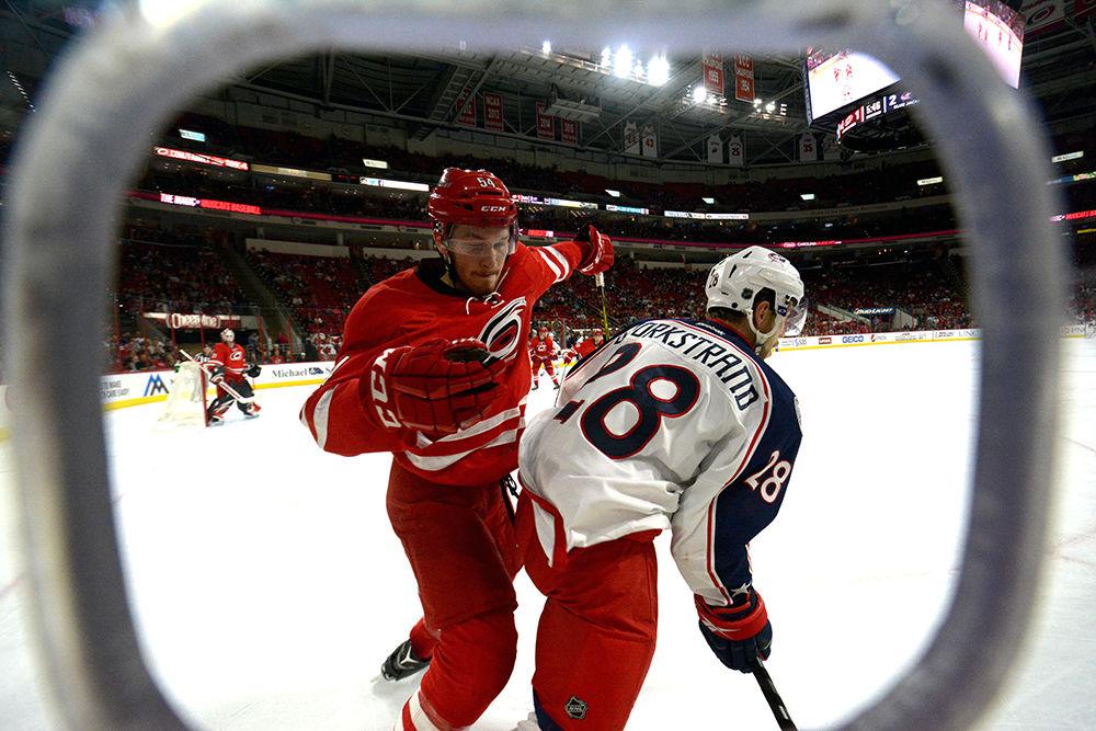 Hurricanes' defenseman Brett Pesce attacks Blue Jackets' forward Oliver Bjorkstrand during the second period of Saturday's game at PNC Arena. Bjorkstrand ended up scoring the Blue Jackets' fifth and final goal during the third period. The Hurricanes ultimately fell to the Blue Jackets 5-1.