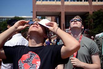 Maciej Kedzierski a first-year engineering student views the eclipse through both glasses and a paper solar filter while Matt Norris a first-year business student also views the eclipse through his glasses at the Brickyard on Monday, Aug. 21. This was the first time in 99 years a total solar eclipse could be viewed over the entire continental United States. The College of Sciences hosted a celebration full of science activities and safe ways to view the eclipse. "This is truly a once in a lifetime experience" Norris said.