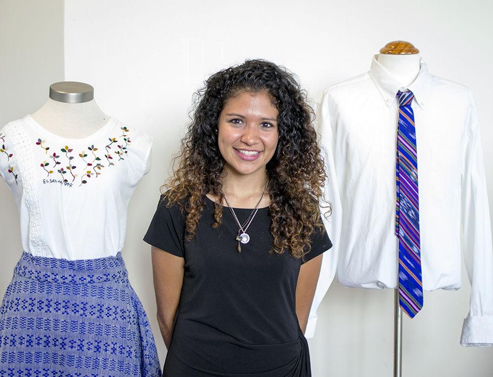NC State alumnus Lisbeth Arias stands with her clothes at the entrance of the College of Textiles on Saturday. Arias is the founder and creative director of Descalza, a Latino-inspired fashion label.