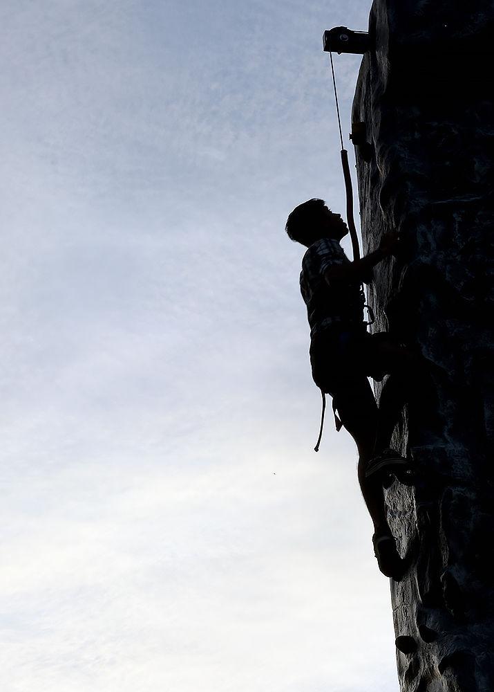 Niket Mistry a graduate student studying industrial engineering ascends the rock climbing station at this year's RecFest on Sunday, August 13 on Miller Field. Mistry climbs five days a week in Carmicheal Gym.