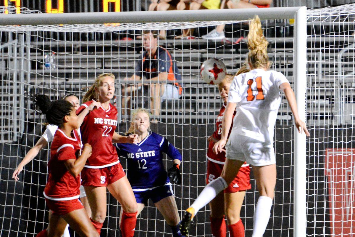 Players dive in the goal to block a header from a Virginia player. The NC State women's soccer team tied Virginia 0-0 in double overtime at Dail Soccer Stadium on Friday, Sep. 15.