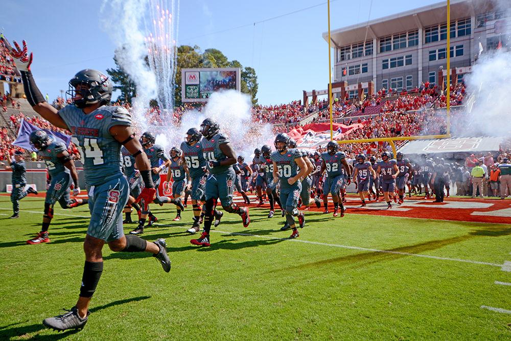 Fireworks announce their entrance as the football team takes the field. The NC State football team beat Syracuse 33-25 at Carter-Finley Stadium on Saturday.