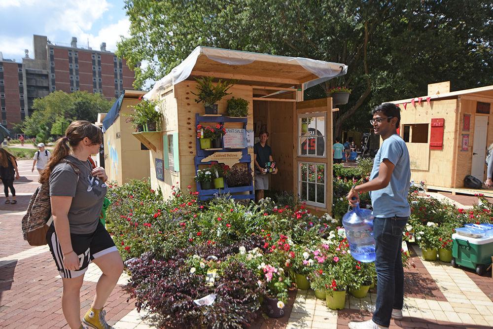 Samantha Hoff, a third-year studying zoology, browses the Caldwell Fellow's selection of plants while Shrikar Nunna, a fourth-year studying chemical engineering and political science, waters the plants Monday. Shack-A-Thon is an annual student-run fundraiser where students eat, sleep and fundraise in the shacks they build. All proceeds go to Habitat for Humanity of Wake County.&#160;