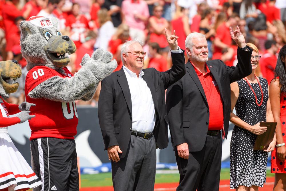 Mr. Wuf, Chancellor Randy Woodson, and Vice-Chancellor Mike Mullen take the field to show support for Parents and Families Weekend. They assisted in honoring the Family of the year.