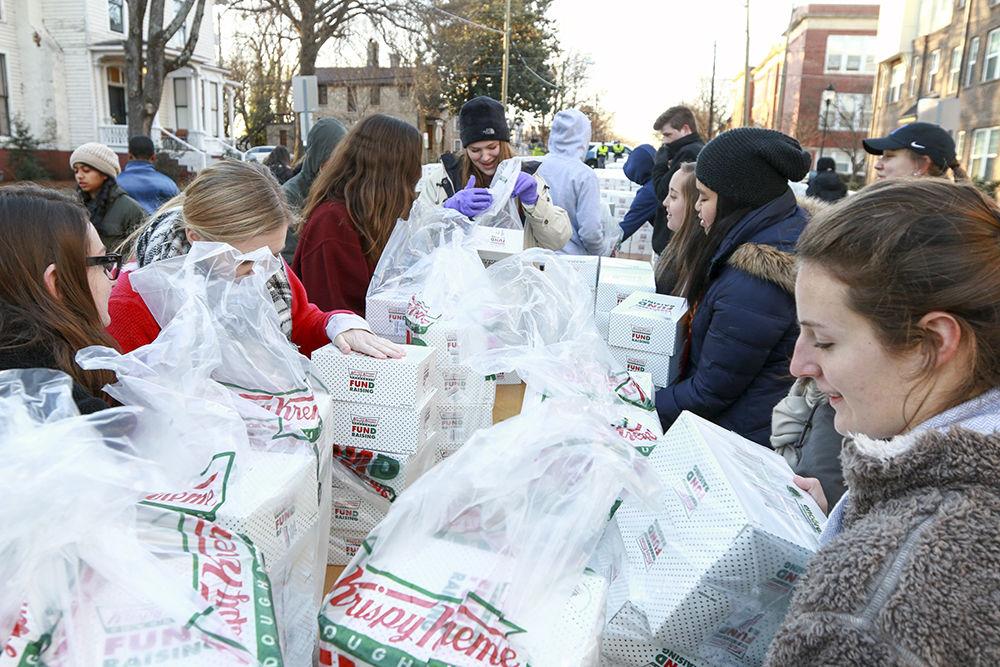 Volunteers unpack boxes of doughnuts to hand out to Krispy Kreme Challenge participants when they reach the halfway point on Feb. 4. Truckloads of doughnuts were shipped by the pallet from Winston-Salem for the annual race that drew over 6,900 participants this year.