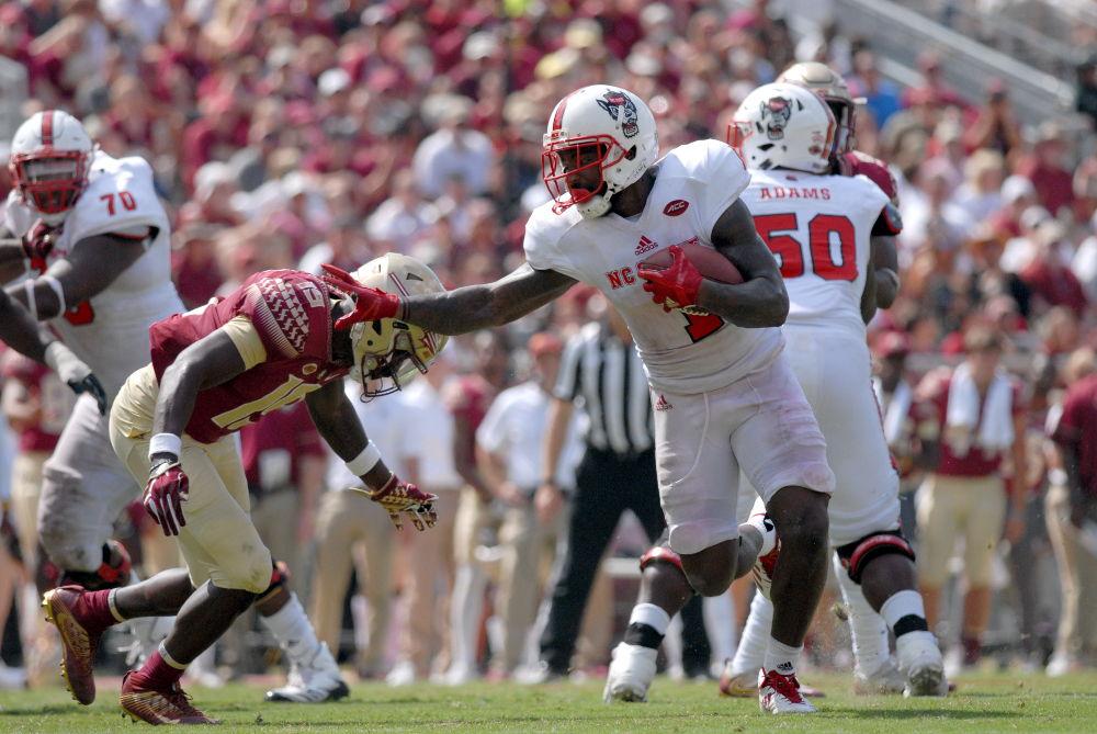 Senior H-back Jaylen Samuels dodges the oncoming defense from Florida State's defensive line as he runs the ball during the N.C. State vs. FSU football game in Doak Campbell Stadium on Saturday. The Wolfpack won 27-21 over the Seminoles in their first conference win of the season.