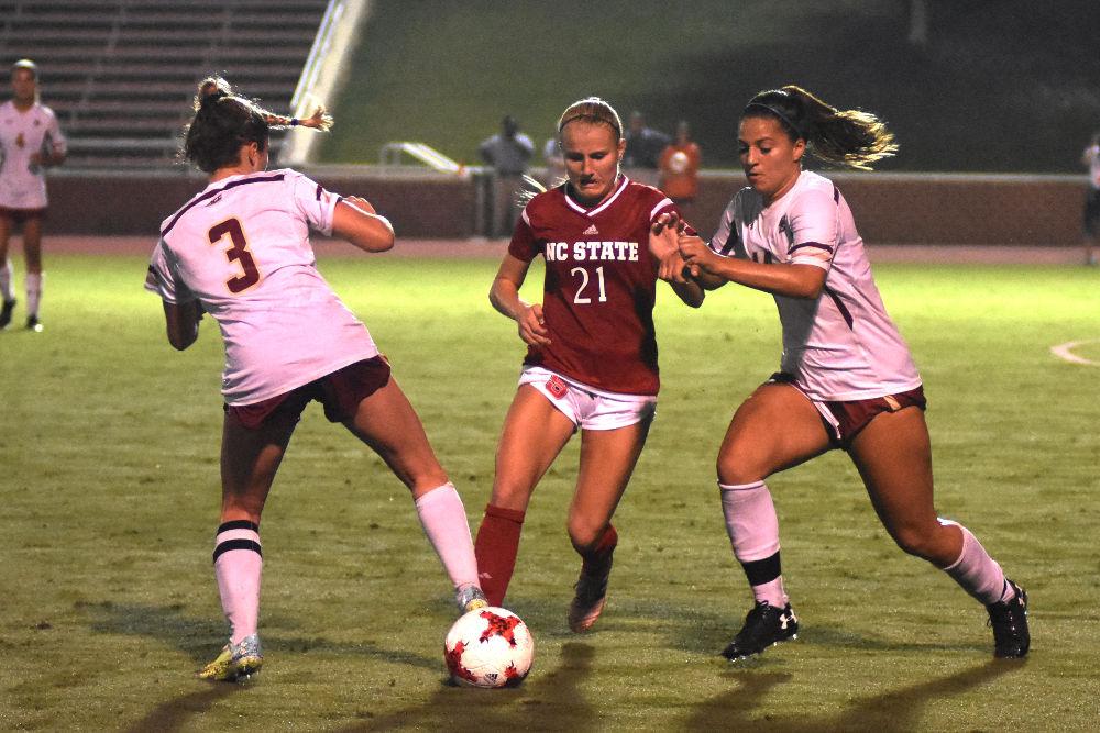 Sophmore midfielder Paige Griffiths fights through two defenders during the game against Boston College. The Wolfpack would go on to win the game 1-0 in Dail Soccer Stadium on Thursday.
