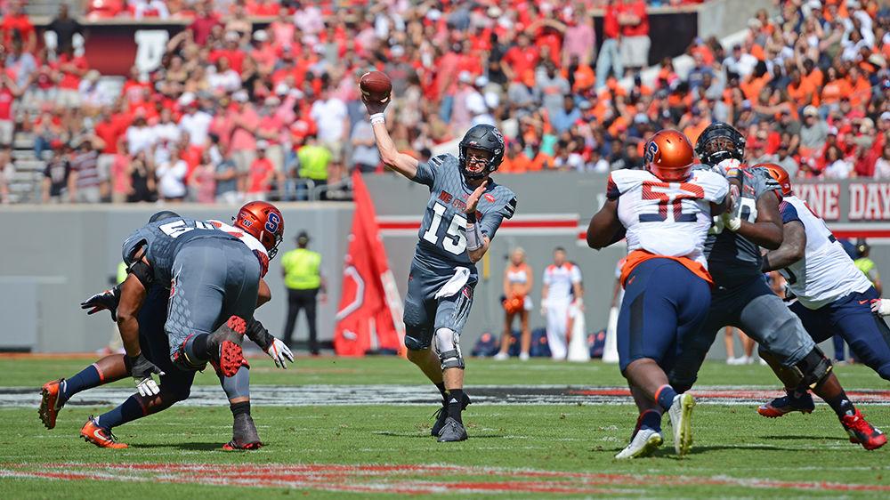 Redshirt graduate quarterback Ryan Finley passes the ball just before multiple Syracuse players break through the NC State defense. The NC State football team beat Syracuse 33-25 at Carter-Finley Stadium on Saturday.