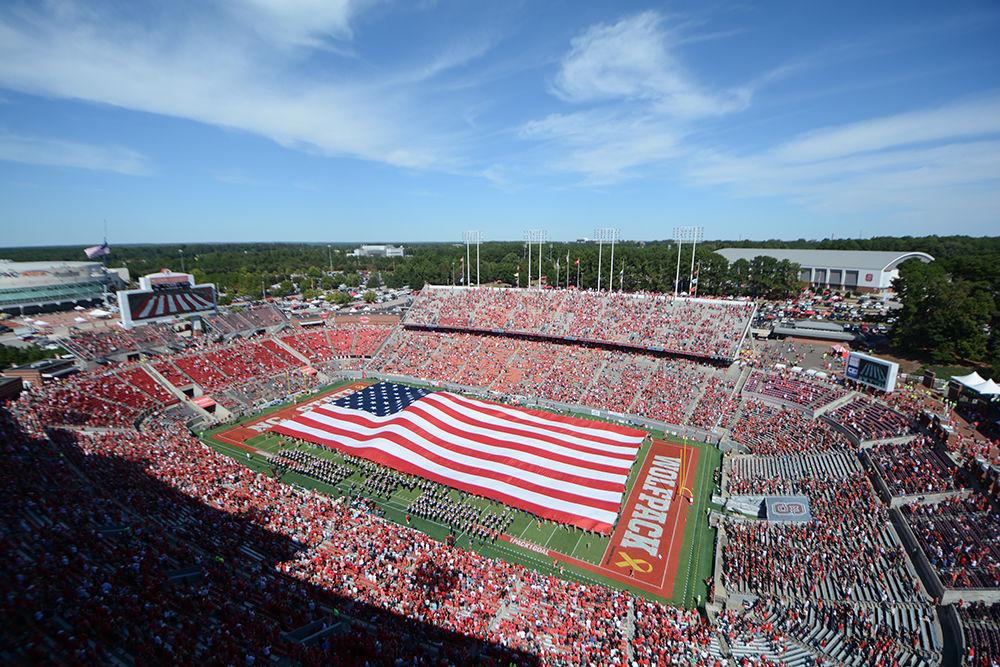 A large American flag is pulled across the field in honor of Military Appreciation Day. The NC State football team beat Syracuse 33-25 at Carter-Finley Stadium on Saturday.