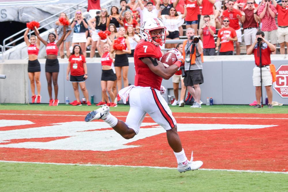 Nyheim Hines, a junior running back, turns to look for defenders while running the ball in for a touchdown during the game against Furman in Carter-Finley Stadium, Saturday, Sept. 16. The Wolfpack won against Furman University, 49-16.
