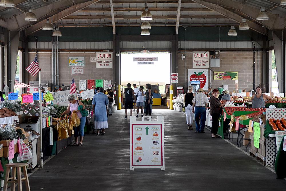 Visitors shop for fresh produce and other goods at the State Farmers Market Farmers Building. The Farmers Building provides 30,000 square feet for North Carolina farmers to sell fresh produce and plants. The Farmers Building is one of several structures that make up the State Farmers Market.