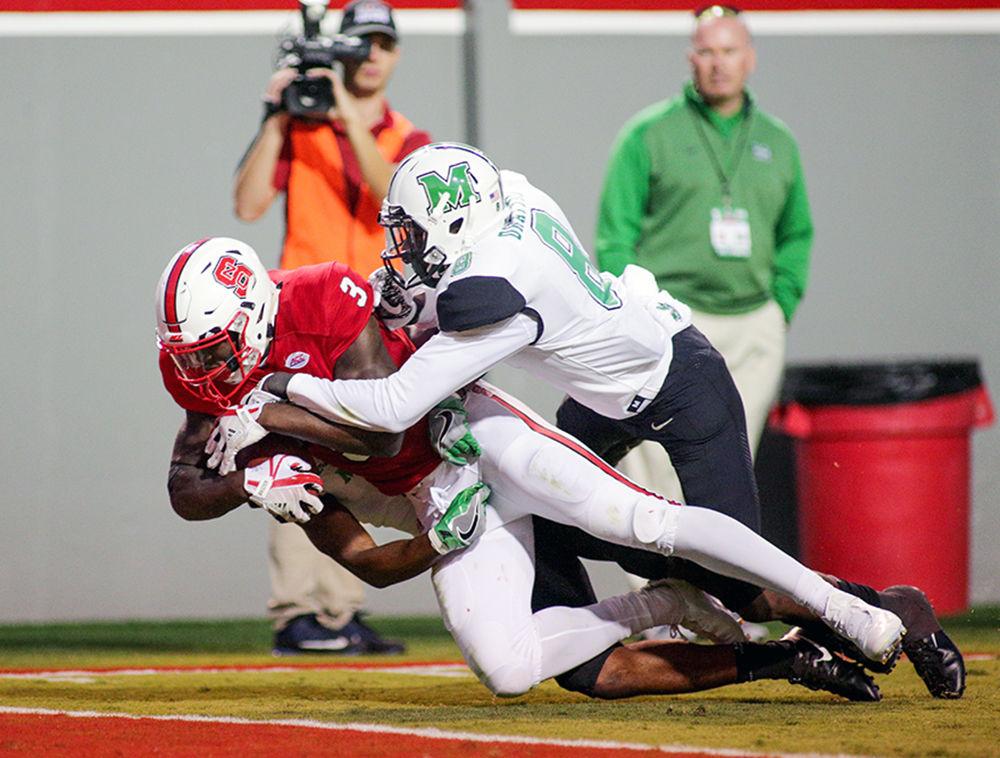 Sophomore wide receiver Kelvin Harmon drags two Marshall defenders into the end zone with him for a touchdown with seconds left in the first half. Harmon led the team with 121 yards through the air during the 37-20 win over Marshall on Saturday in Carter-Finley Stadium.
