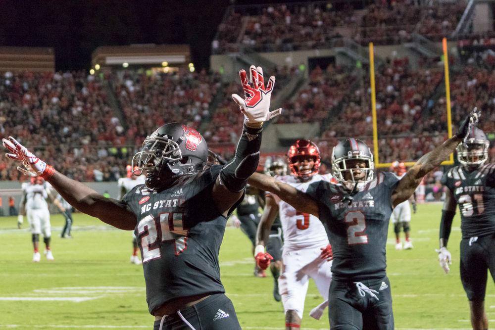 Senior nickleback Shawn Boone and senior cornerback Mike Stevens celebrate a stop in the 39-25 win over Louisville in Carter-Finley Stadium on Thursday, October 5